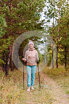 An elderly woman in sportswear with sticks