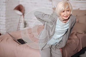 Elderly woman standing with backache