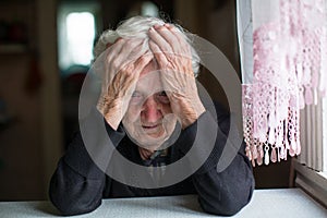 An elderly woman in a state of depression. Pensioner.