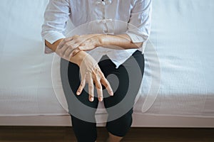 Elderly woman suffering with parkinson`s disease symptoms