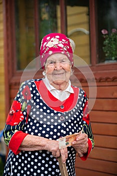 elderly woman in the summer holds money in her hands