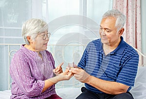 Elderly woman supporting sick senior man and giving pills to husband, medication vitamins supplement