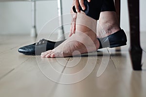 Elderly woman swollen feet putting on shoes