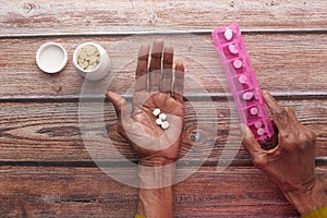 Elderly woman taking medicine from pill box