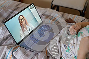 An elderly woman is talking with a doctor on Skype. A pensioner suffers from a respiratory disease and blows her nose