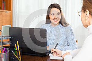 Elderly woman talking with young girl employee