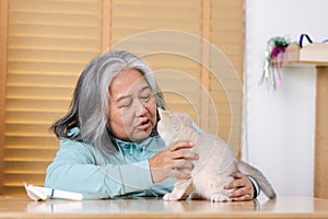 An elderly woman talks and plays with the kittens she raised to relieve loneliness in the house