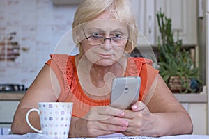 Elderly woman texts on mobile phone