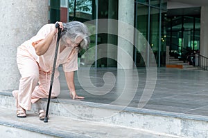 Elderly woman trying to stand up, Using a cane to help