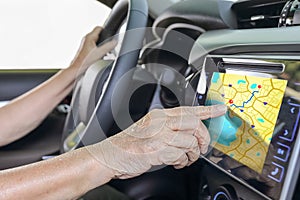 Elderly woman using GPS navigation system in car