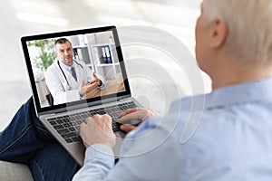 Elderly woman using laptop at home, making video call with doctor, having online conference with medical specialist