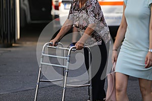 Elderly woman using a metal walker