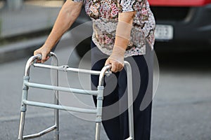 Elderly woman using a metal walker