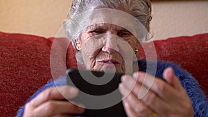 Elderly woman using a mobile phone. Happy smiling grandmother holds a smartphone