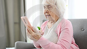 Elderly Woman Using Smartphone For Chatting With Relatives