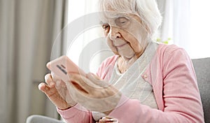 Elderly Woman Using Smartphone Reading Internet News