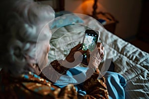 Elderly woman using smartphone to view nature photo indoors