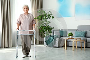 Elderly woman using walking frame indoors.  for text