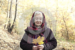 Elderly woman on a walk in autumn park