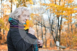 Elderly woman on a walk in autumn park