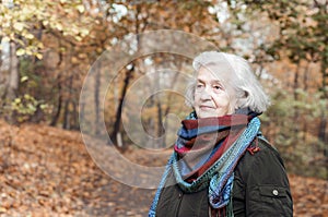 Elderly woman on a walk in autumn park