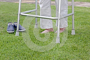 Elderly woman walking barefoot therapy on grass in backyard.