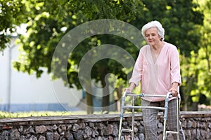 Elderly woman with walking frame . Medical help