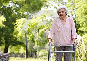 Elderly woman with walking frame outdoors