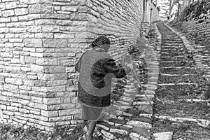 An elderly woman walking the streets of Vitsa in Zagori area in Northern Greece