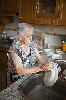 Elderly woman washing dishes