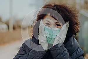 Elderly woman wearing facial mask and gloves to prevention of infection