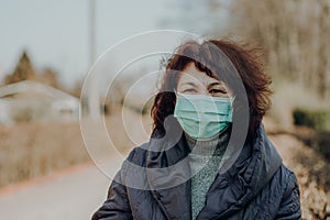 Elderly woman wearing facial mask and gloves to prevention of infection