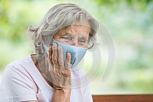 Elderly woman wearing a protective face mask against viruses