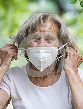 Elderly woman wearing a protective face mask against viruses