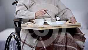 Elderly woman wheelchair eating dinner in nursing home, hospital service, food