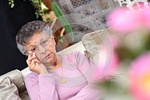 Elderly woman wiping tears