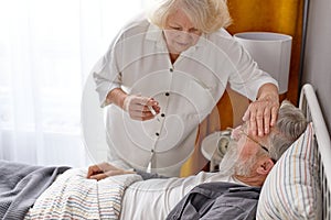 elderly woman is worried about health condition of sick husband