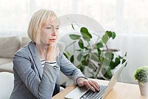 Elderly woman writer in white working on new article