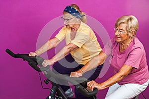 Elderly women doing leg exercises in gym.