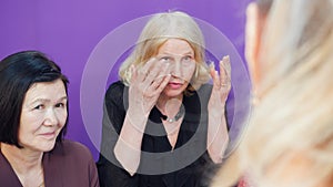 Elderly women gossip with each other, discussing their problems.