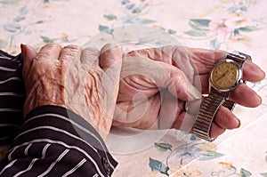 Elderly women holding her watch