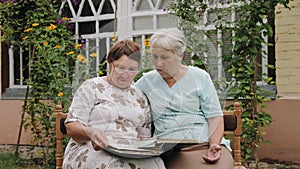 Elderly women look at old photos in an album