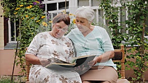 Elderly women look at old photos in an album