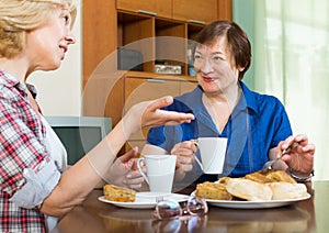 Elderly women at the table with tea