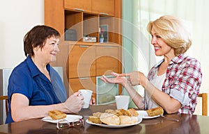 Elderly women at the table with tea