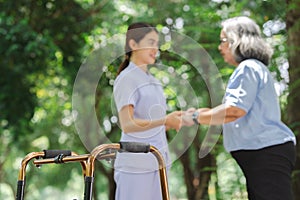 Elderly women using walking aids for exercises to improve muscle strength, flexibility with nurse.