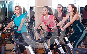 Elderly and young women working out hard in sport club