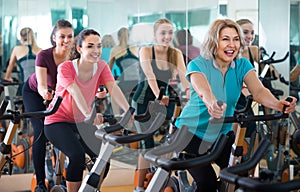 Elderly and young women working out hard in sport club