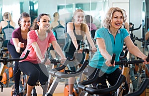 Elderly and young women working out hard in sport club