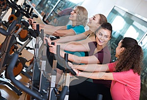 Elderly and young women working out hard in sport club